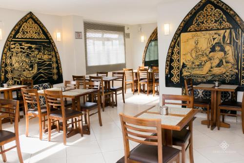 a dining room with wooden tables and chairs at Fenicia Palace Hotel in Varginha