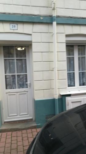 une maison avec une porte et une voiture garée à l'extérieur dans l'établissement maison de pêcheur, au Tréport