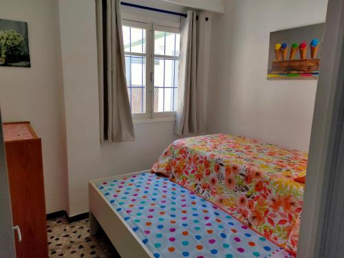 a small bedroom with a bed and a window at Tranquila casa frente al mar in Adra