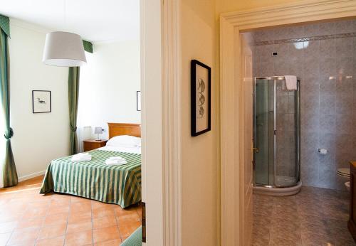 - une chambre avec un lit et une douche dans l'établissement Residence Villa Marina, à Grado