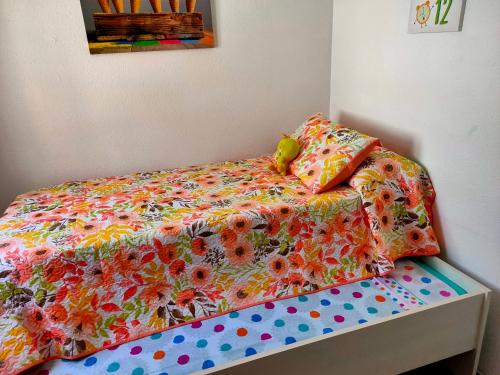 a bed with a colorful comforter and pillows on it at Tranquila casa frente al mar in Adra