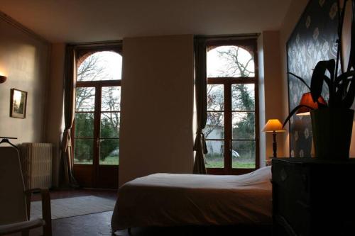 - une chambre avec deux fenêtres et un lit avec des draps blancs dans l'établissement Maison Bois Renard, à Saint-Laurent-Nouan