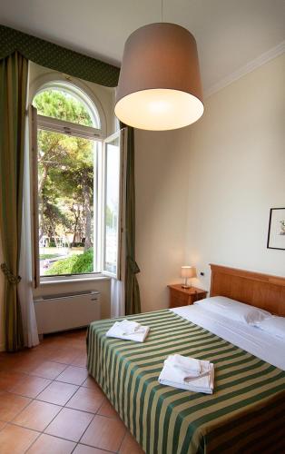 a bedroom with a bed with a large window at Residence Villa Marina in Grado