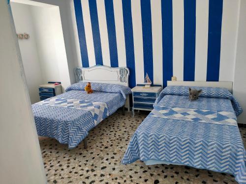 a bedroom with two beds with a dog laying on them at Tranquila casa frente al mar in Adra