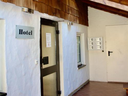 a hotel sign on the side of a building with a door at Hotel Alt Ebingen in Albstadt