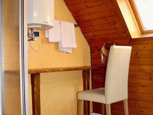 ein Bad mit einem weißen Stuhl in einem Zimmer in der Unterkunft Hotel Alt Ebingen in Albstadt
