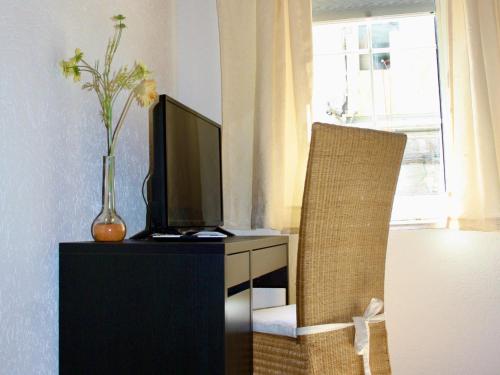 a living room with a tv and a chair at Hotel Alt Ebingen in Albstadt