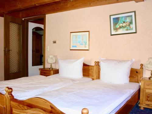 a bedroom with two beds with white sheets at Hotel Alt Ebingen in Albstadt
