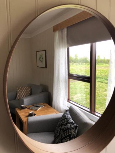 a mirror in a living room with a couch and a table at Hotel Raudaskrida in Þóroddsstaður