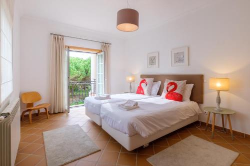 カザル・ダ・ラゴア・セッカにあるVila dos Principesのベッドルーム1室(大型ベッド1台、赤い枕付)