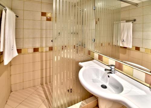 普里莫爾斯科的住宿－木蘭酒店，白色的浴室设有水槽和淋浴。
