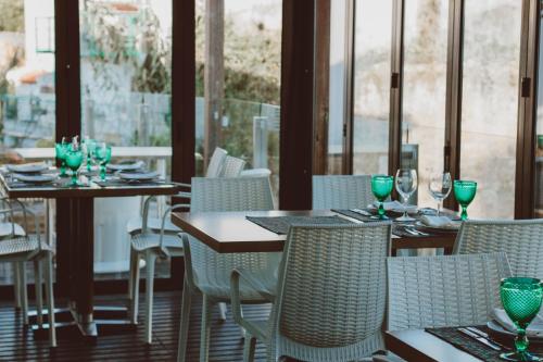 un restaurante con mesas y sillas y copas de vino en Hotel Casa da Nora, en Leiria