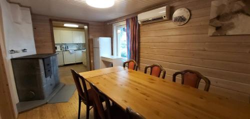 a dining room with a wooden table and chairs at Hideaway Cottage in Ivalo