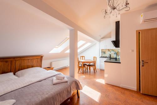 ein Schlafzimmer mit einem Bett und eine Küche mit einem Tisch in der Unterkunft Kamienica Zamenhofa - Apartamenty na wynajem in Białystok