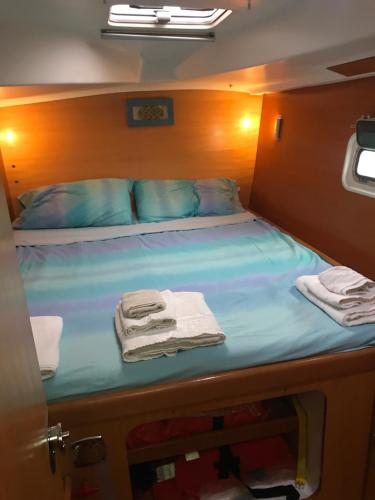 Una cama en una habitación pequeña con toallas. en Catamarano Miragua - Resort on board in Catania, en Catania