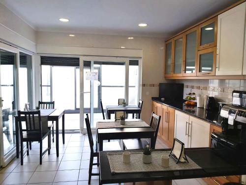 a kitchen and dining room with tables and chairs at Milfontes Guest House - Duna Parque Resorts & Hotels in Vila Nova de Milfontes