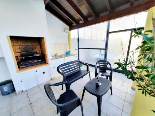 two chairs and a table in a room with a fireplace at Milfontes Guest House - Duna Parque Resorts & Hotels in Vila Nova de Milfontes