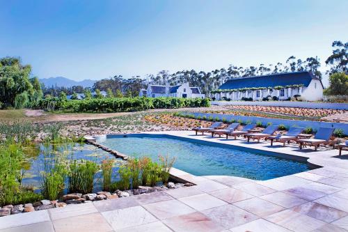 a swimming pool with lounge chairs and a resort at Rijk's Guesthouse in Tulbagh