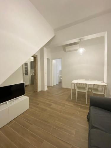 uma sala de estar com um sofá, uma televisão e uma mesa em Ca' Lucia Apartment em Veneza