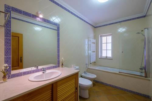 a bathroom with a sink and a toilet and a tub at D. Sebastião Townhouse in Casal da Lagoa Seca