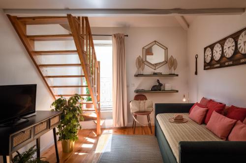a living room with a couch and a staircase at Alfama Yellow House in Lisbon