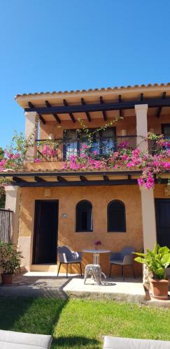a building with a balcony with pink flowers on it at Casa Naya Rural in Sant Llorenç de Balafia
