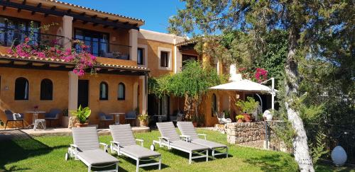 a group of chairs in the yard of a house at Casa Naya Rural in Sant Llorenç de Balafia