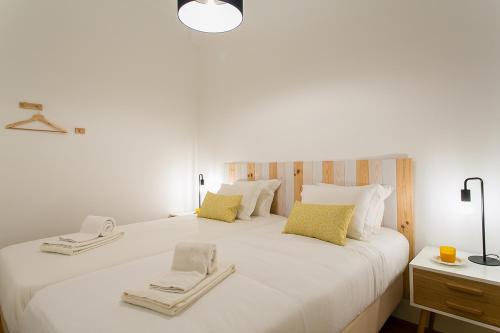 a bedroom with a large white bed with towels on it at LovelyStay - Cozy 3BDR Apartment in Estrela in Lisbon