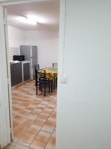 a room with a table and chairs and a kitchen at Appartement de la Baie in Le Vauclin