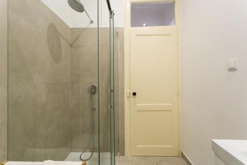 La salle de bains est pourvue d'une douche avec une porte en verre. dans l'établissement LovelyStay - Cozy 3BDR Apartment in Estrela, à Lisbonne