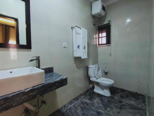 a bathroom with a sink and a toilet and a mirror at Residency Hotel Lagos Airport in Lagos