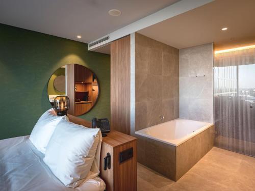 a bedroom with a bed and a bath tub at Van der Valk Hotel Amsterdam Zuidas -Rai in Amsterdam