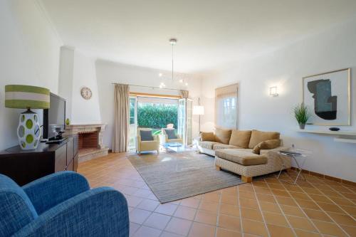 a living room with a couch and chairs and a tv at Principes Townhouse in Casal da Lagoa Seca