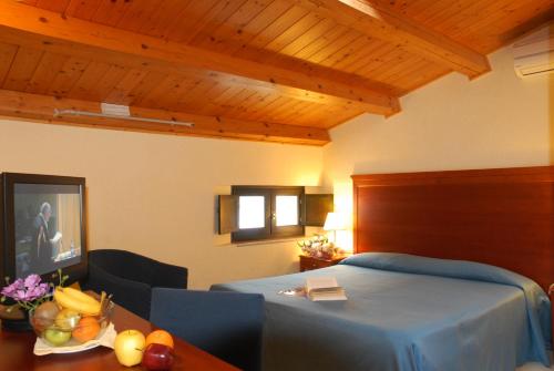 a bedroom with a bed and a table with fruit on it at Park Hotel Villa Americana in Rodi Garganico
