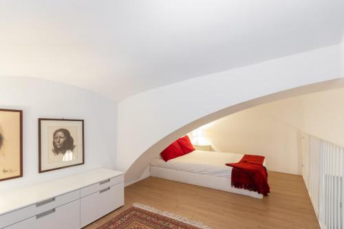 a white bedroom with a bed with red pillows at Charming Studio near Piazza Castello by Wonderful Italy in Turin