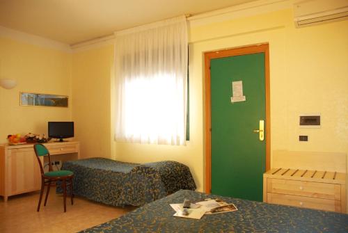 a hotel room with a bed and a desk and a window at Park Hotel Villa Americana in Rodi Garganico