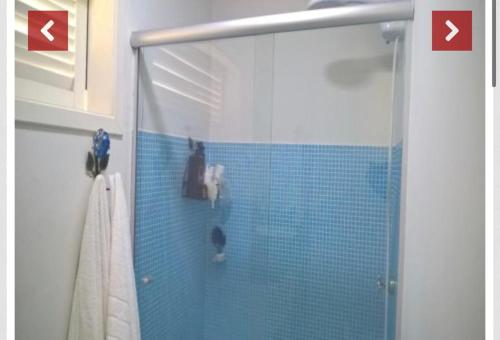 a bathroom with a glass shower with a person in it at Casa com piscina ubatuba in Ubatuba