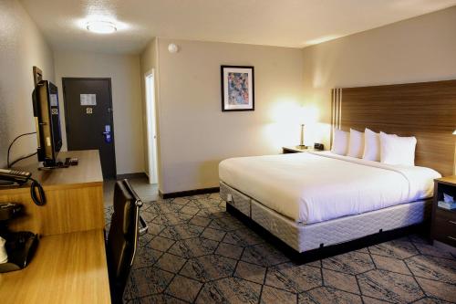 a hotel room with a bed and a flat screen tv at Baymont by Wyndham Effingham in Effingham
