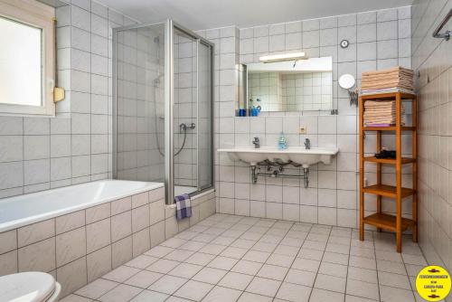 ein Bad mit einer Badewanne, einem Waschbecken und einer Dusche in der Unterkunft Ferienwohnung beim Europa-Park Rust in Rust