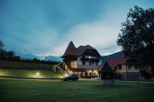 une voiture garée devant une grande maison dans l'établissement VILLA GHERMAN, à Sălciua de Jos