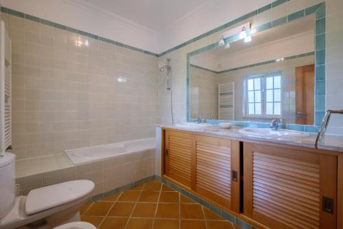 a bathroom with a sink and a tub and a toilet at Principes Townhouse in Casal da Lagoa Seca