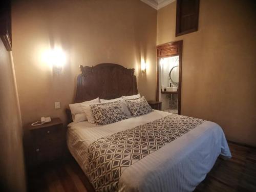 a bedroom with a large bed with a wooden headboard at Hotel Boutique Casa de las Manrique in Guanajuato