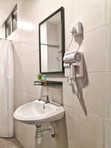 y baño con lavabo, espejo y secador de pelo. en My Cool Home x The Quintet @ Cameron Highlands, en Tanah Rata