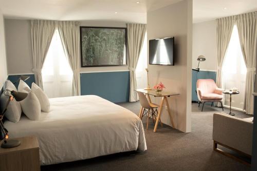 um quarto com uma cama, uma mesa e uma cadeira em Casa Republica Barranco Boutique Hotel em Lima