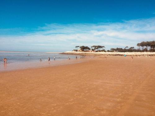 a beach with a bunch of people in the water at Mobil Home La Palmyre Camping Bonne Anse 4 étoiles in Les Mathes