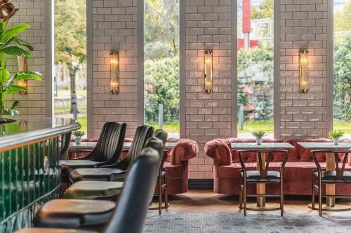 a restaurant with chairs and tables and windows at The ReMIX Hotel in Paris