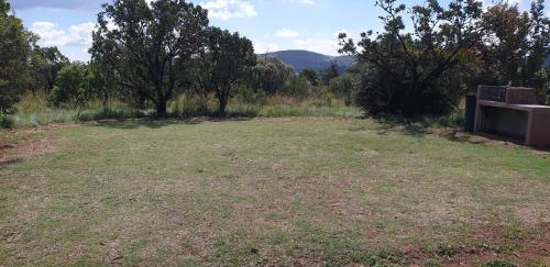 a large grass field with a bench in the middle at Milorho Lodge in Rietfontein