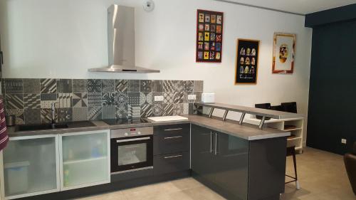 une cuisine avec une cuisinière et un comptoir dans l'établissement les Aromatiques - terrasse & parking privé à VILLENEUVE LES AVIGNON - proche Golf Academy, à Villeneuve-lès-Avignon