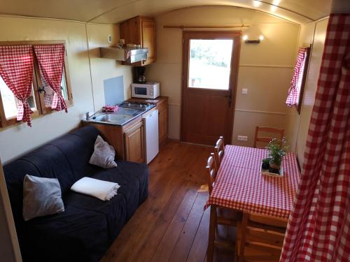 梅内尔伯La Carriole dans le jardin的客厅里有一张沙发和一张桌子。