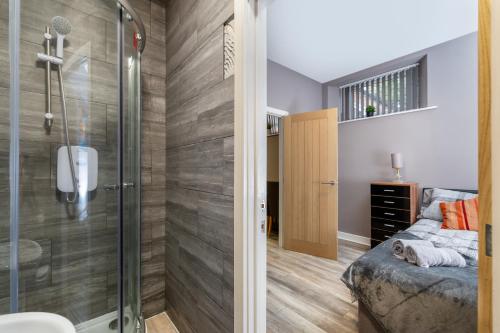 a bathroom with a shower and a bed in a room at Darlington Town Centre Apartments free parking and Wi-Fi in Darlington